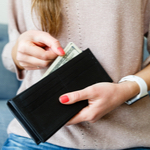 Woman pulling cash out of wallet